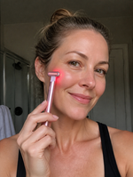 ReWired Glow Wand customer review - woman using wand on cheek, bathroom mirror