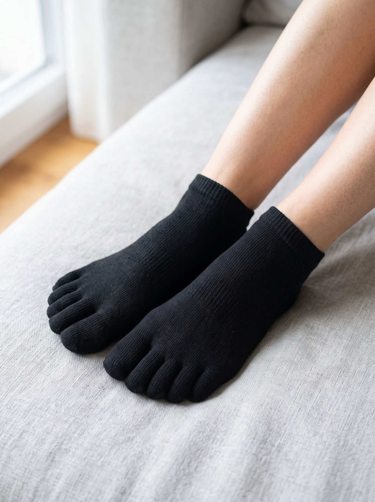 Feet wearing the black five-toe comfort socks